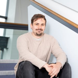 Andrew Widdowson smiling sat on steps