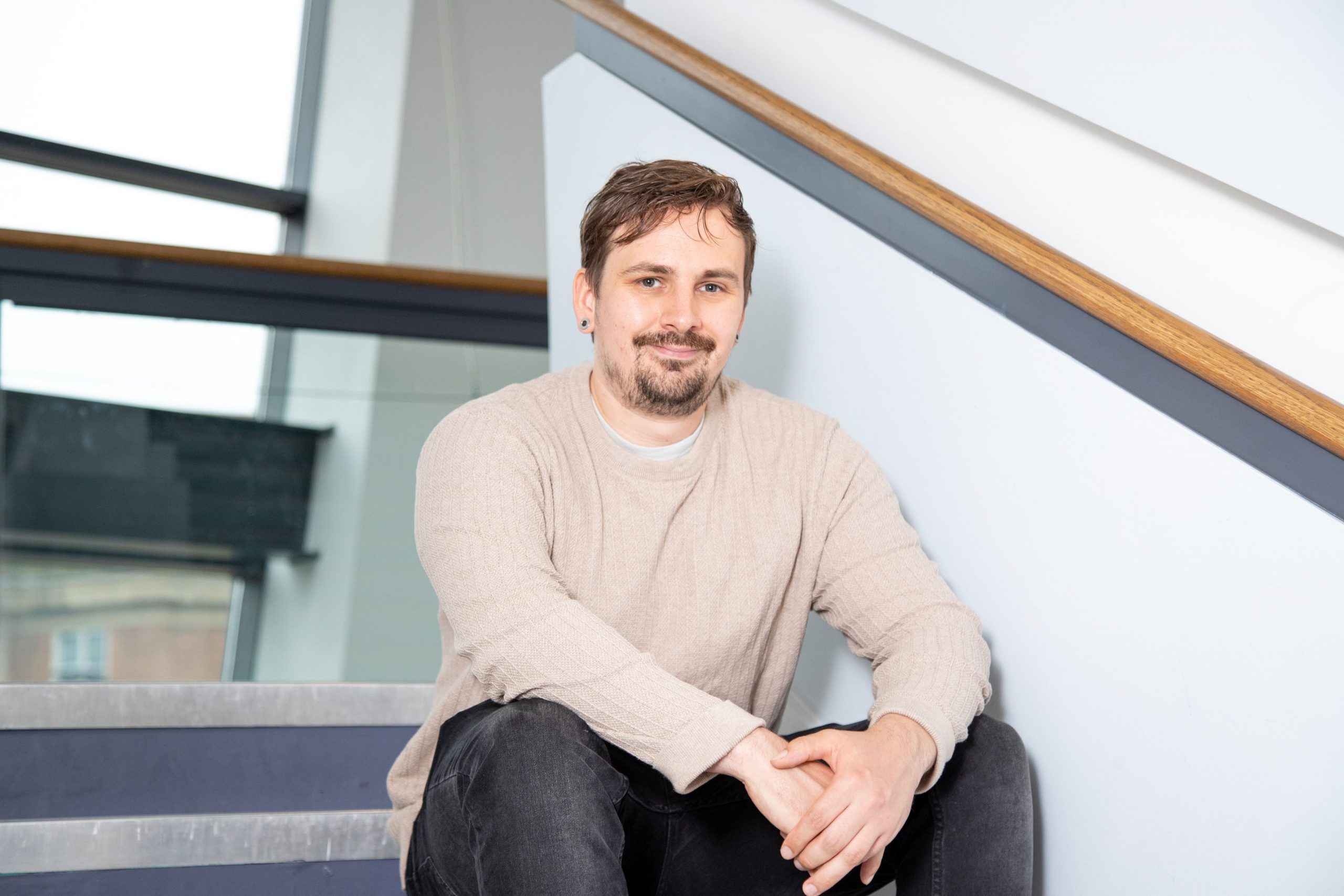 Andrew Widdowson smiling sat on steps